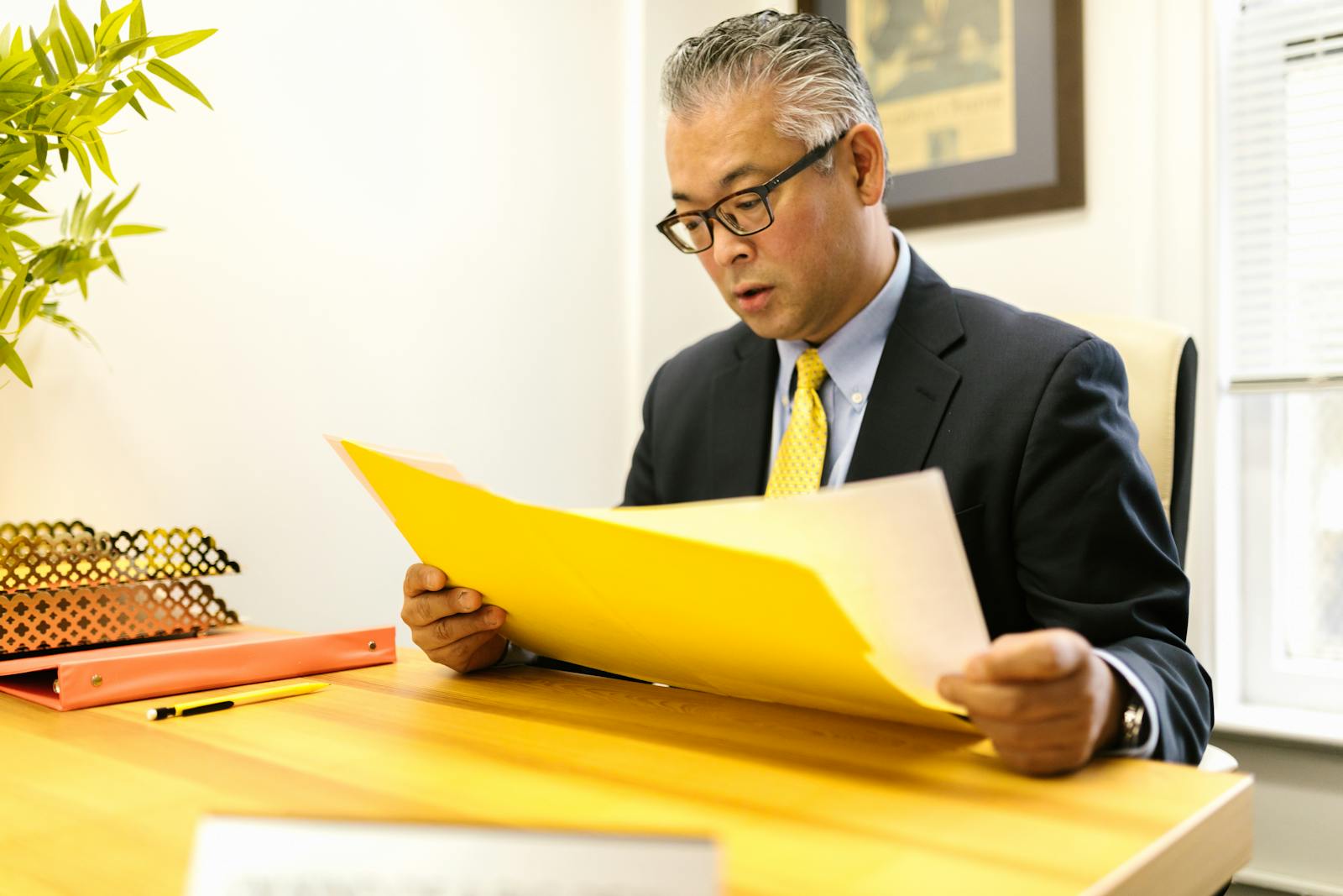 Malaysian SME accounting clerk reviewing AutoCount invoices on a desktop while the Daxonet middleware bridges them to LHDN MyInvois