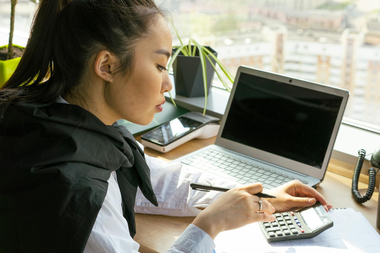 Asian SME owner reviewing AutoCount Cloud Accounting on a laptop