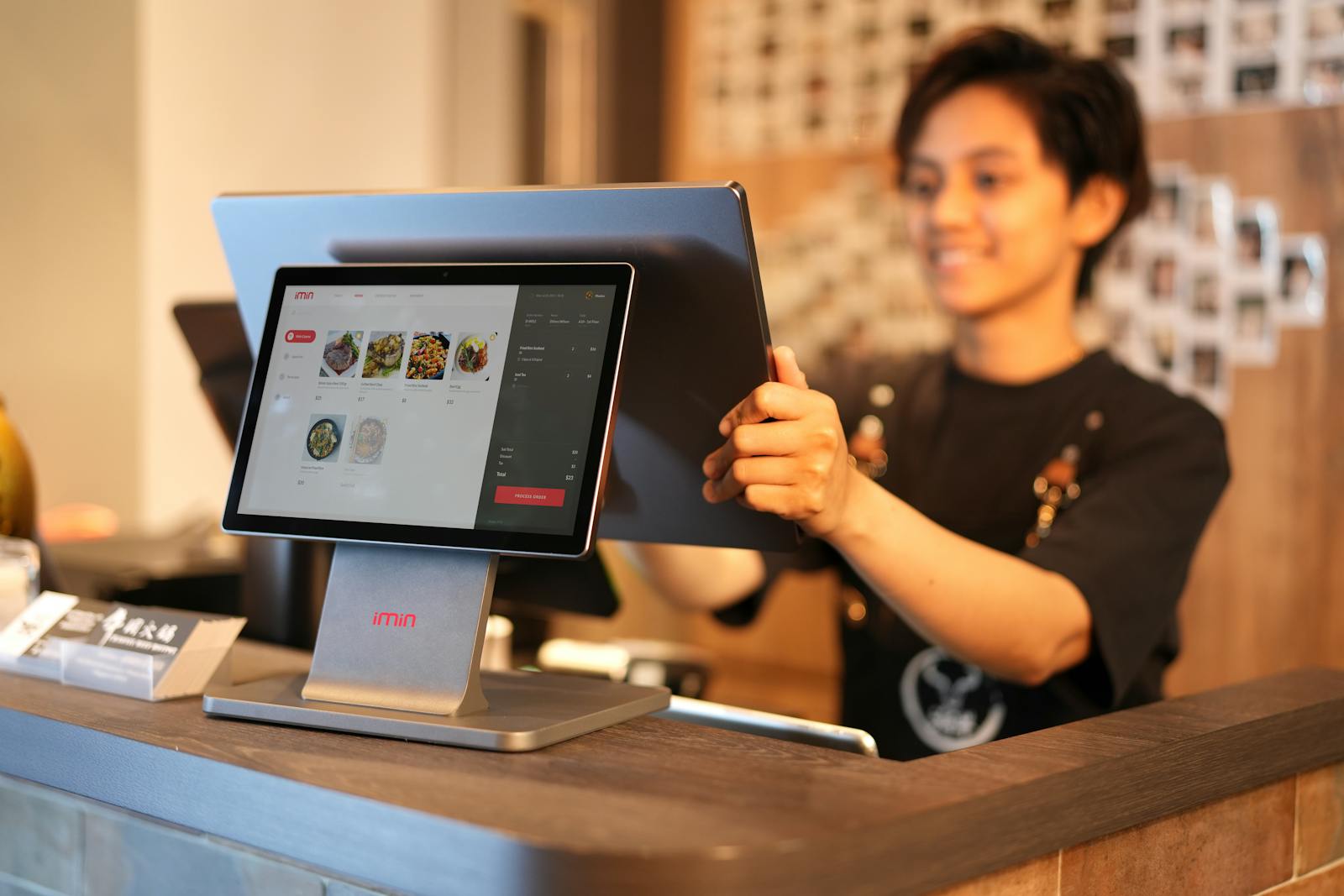 Retail mode — Asian SME cashier with barcode at the till