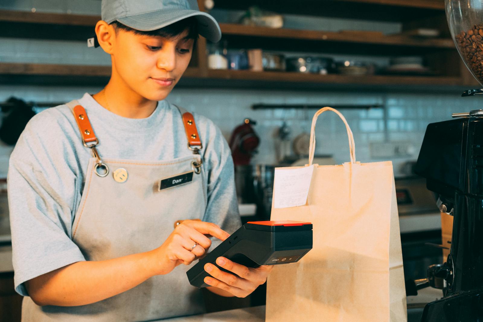 Asian SME cashier ringing up sale on AutoCount POS 5.0 touch-screen terminal